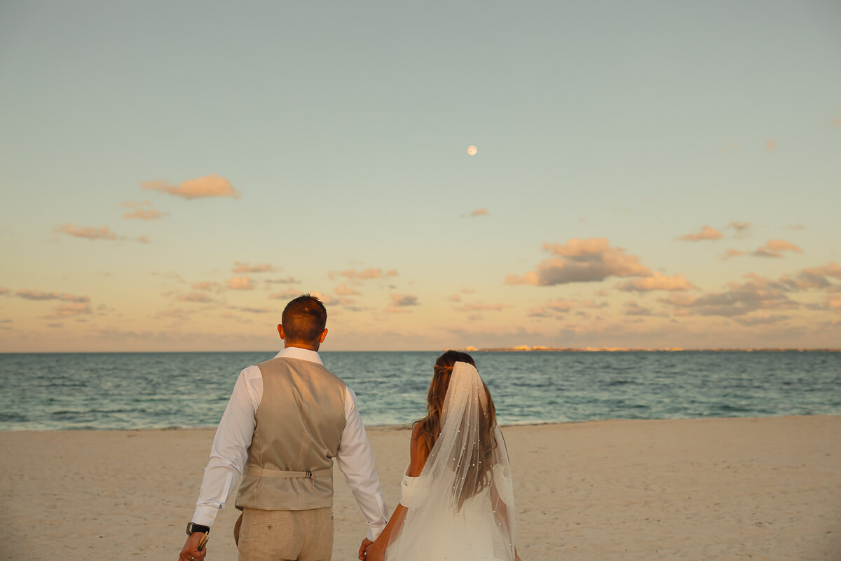 Wedding couple walking along the beach of Cancún, Mexico.