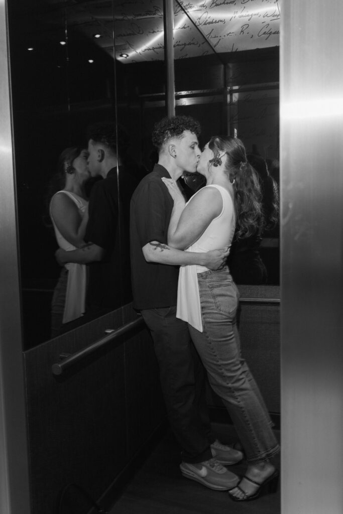 Couple shares a kiss in an elevator in Portland, Oregon during their engagement photos.