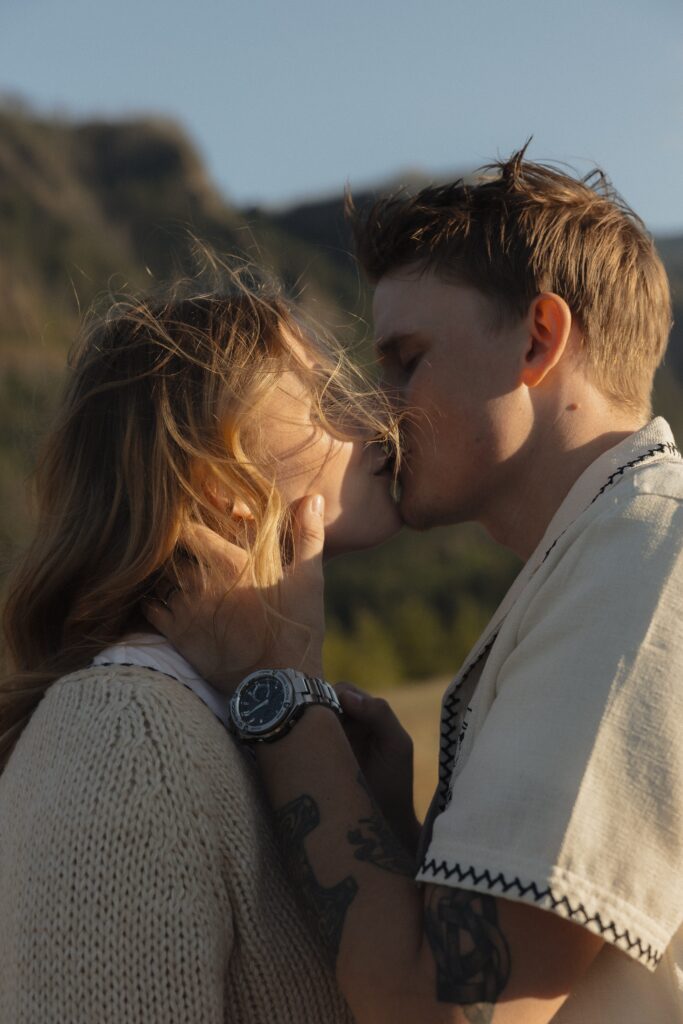 engaged couple shares a kiss in Bonneville, WA