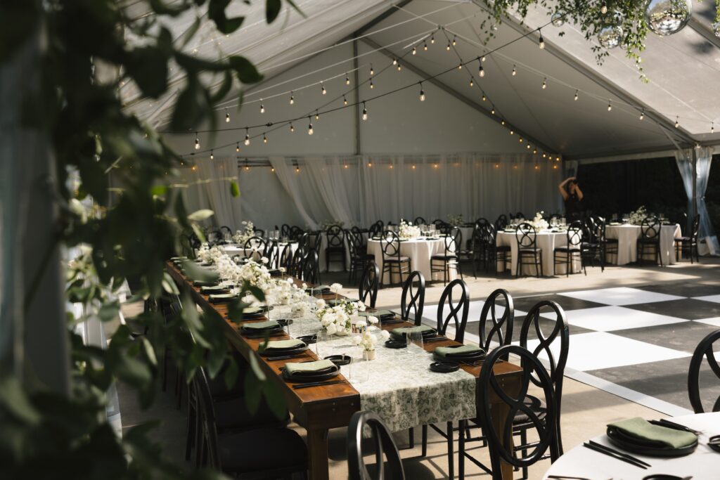 Reception under a glowing clear tent surrounded by oak trees.