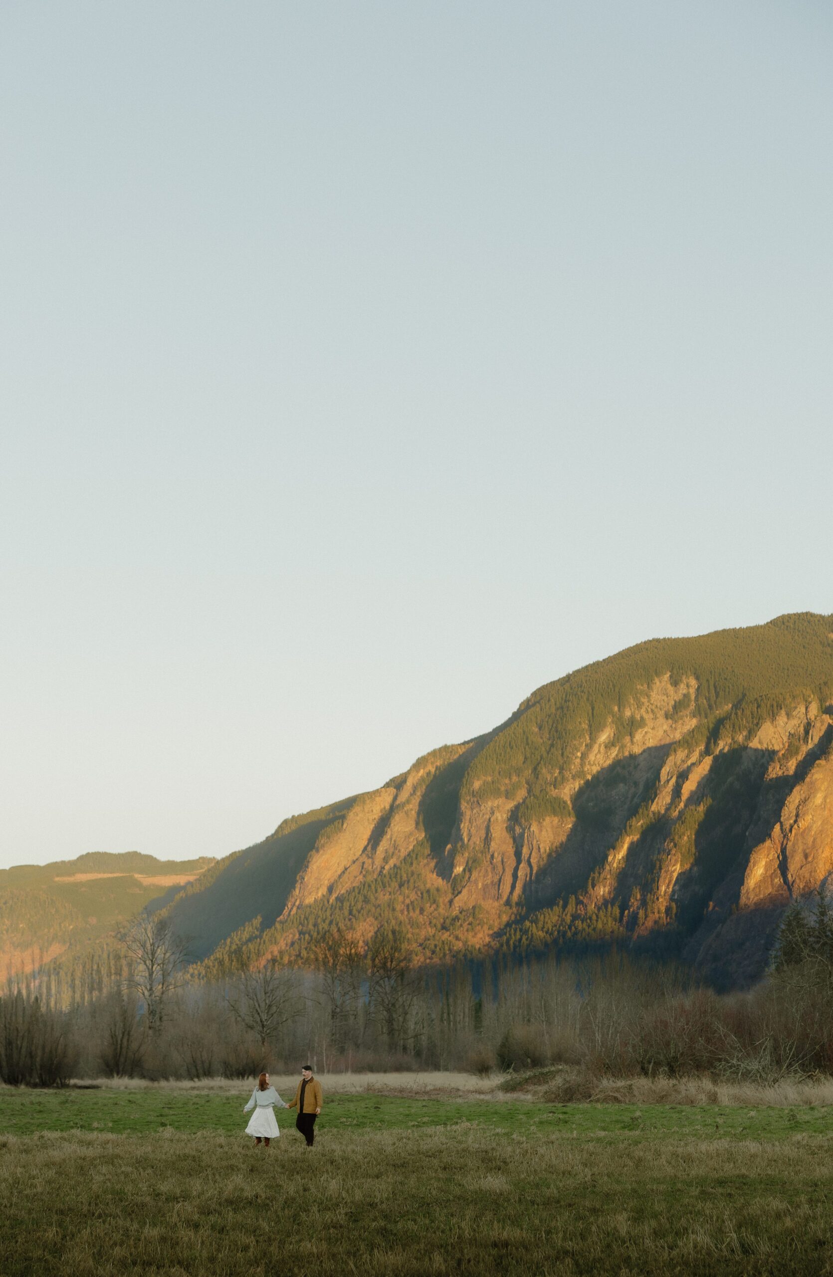 Abby and Henry walking through Elk Fields in Snoqualmie with Mount Si in the distance