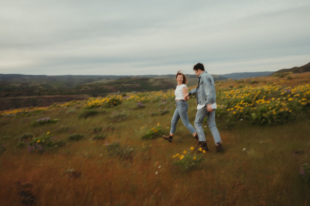 Couple running through wildflowers in Oregon