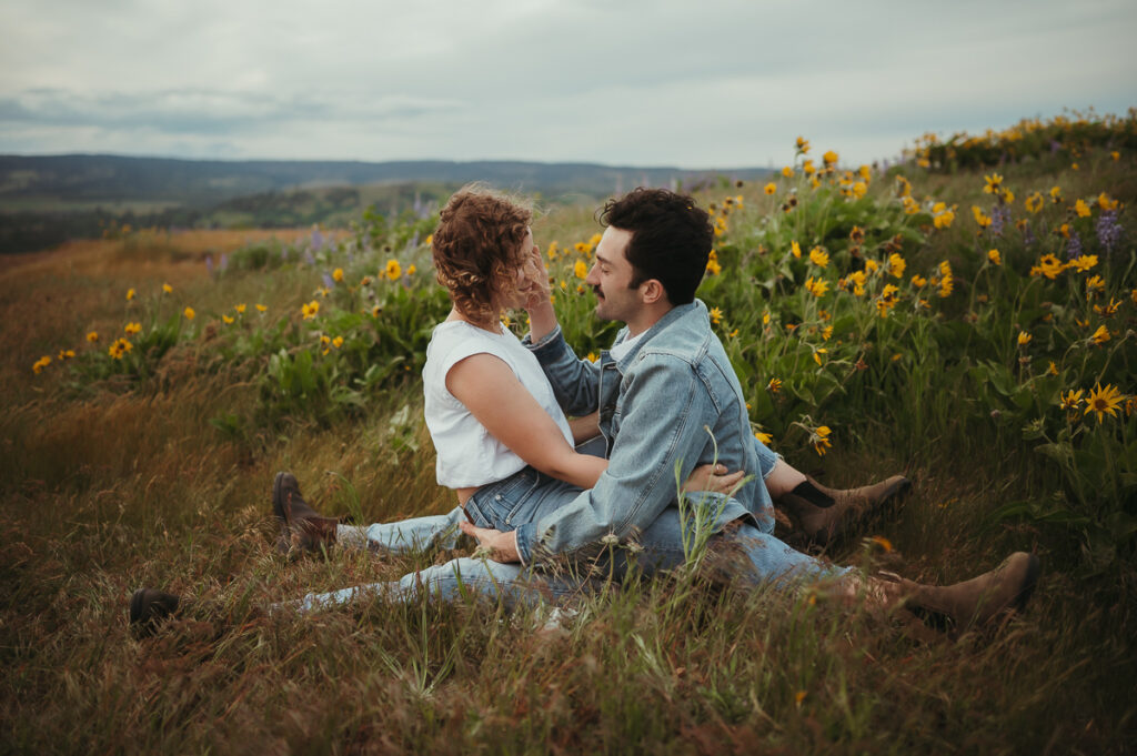 Intimate couple sitting together among wildflowers in the Pacific Northwest